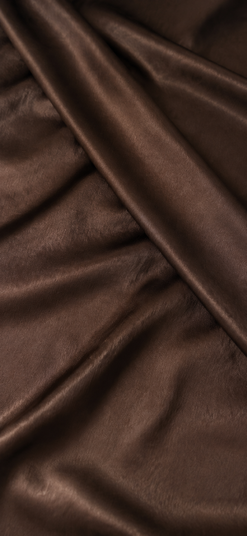 Close-up of crossed folds in chocolate brown fabric